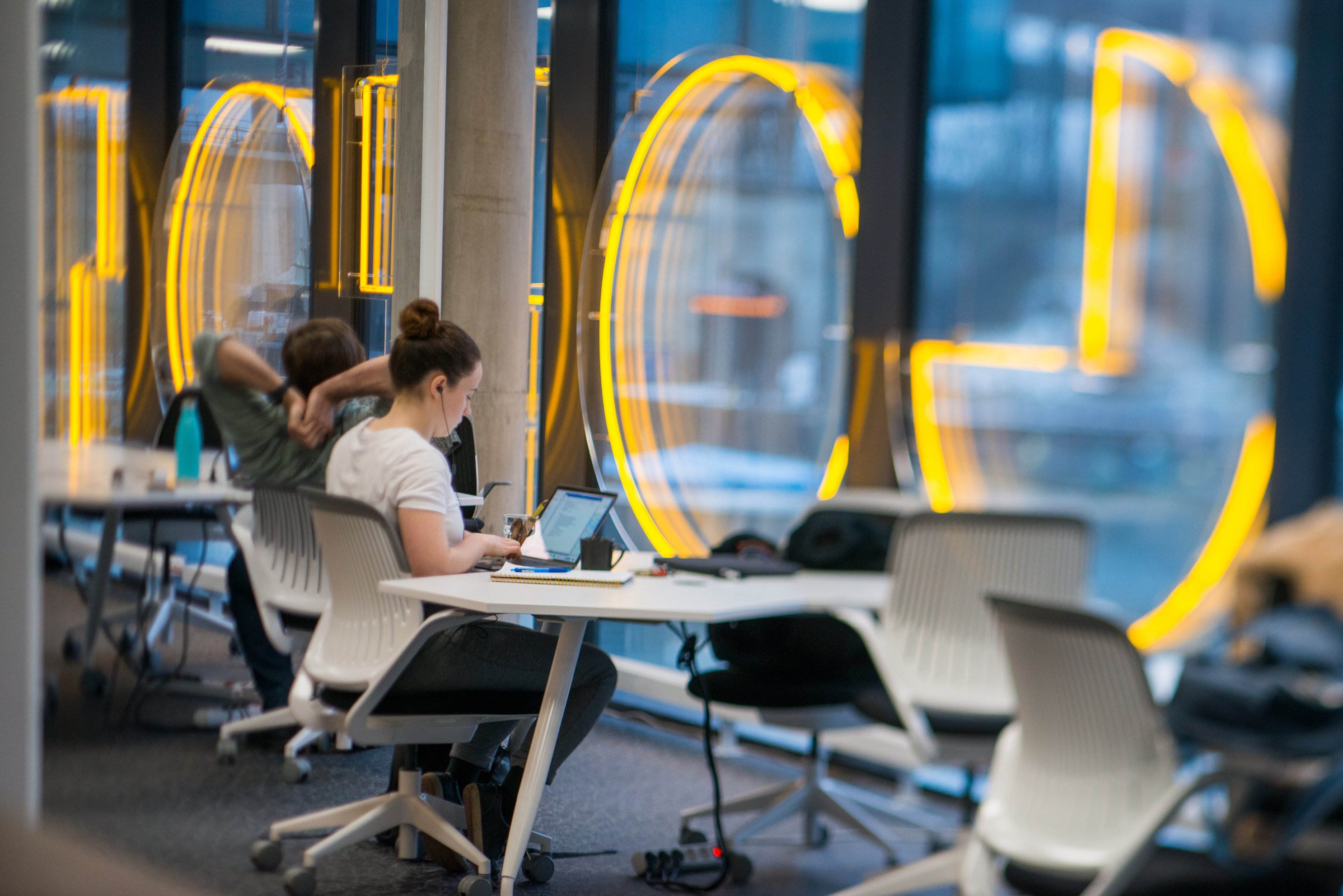 En kvinna och man sitter och arbetar vid en laptop på Goto 10 coworkingspace