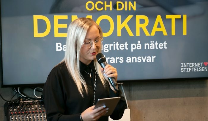 Kvinna håller i mick och presenterar ett seminarium