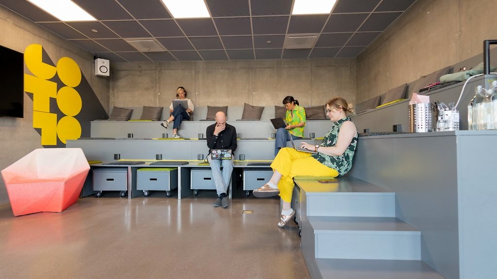 En grupp människor sitter och arbetar vid sina datorer i Gradängen på start- och mötesplatsen Goto 10