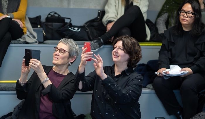 Publik vid event på Goto10. Två kvinnor i publiken fotograferar scenen med varsin mobiltelefon.