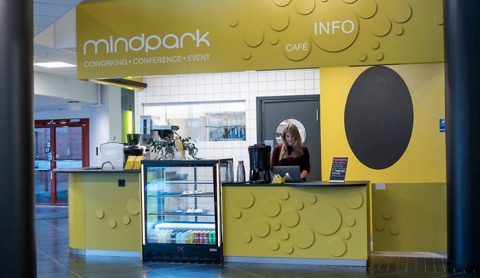 En kvinna står framför dator i disken på The Mindpark Café på Goto 10 Malmö