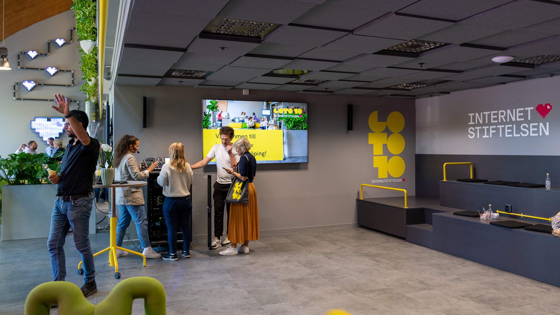 En grupp människor som står framför en tv.